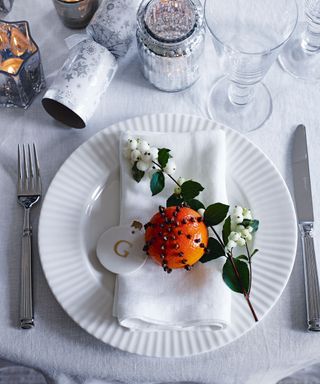 White modern christmas place setting with orange and white berries on place