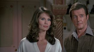 Maud Adams' Octopussy and Roger Moore's James Bond stand close together in Octopussy