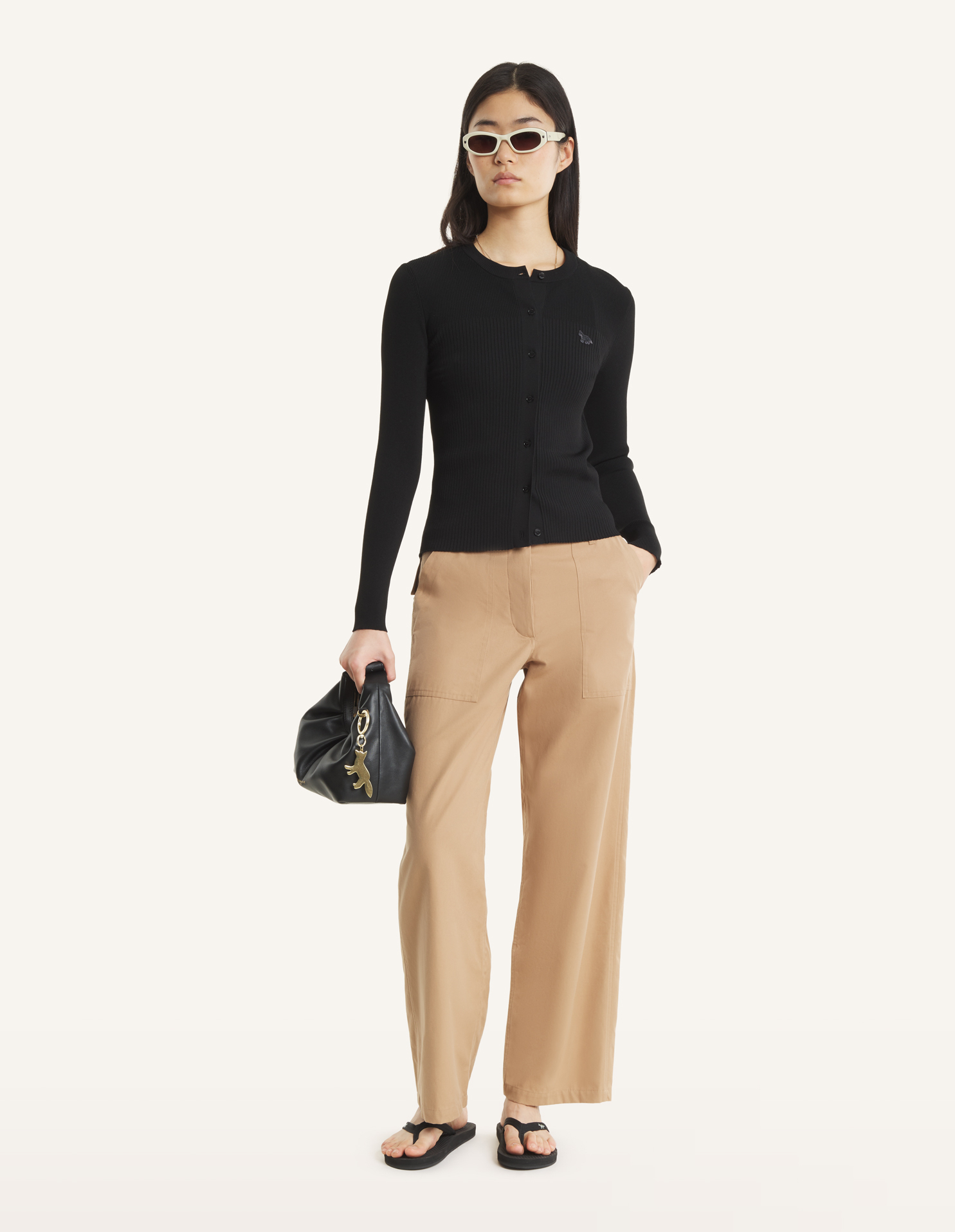 Model wears a Maison Kitsune black cardigan.