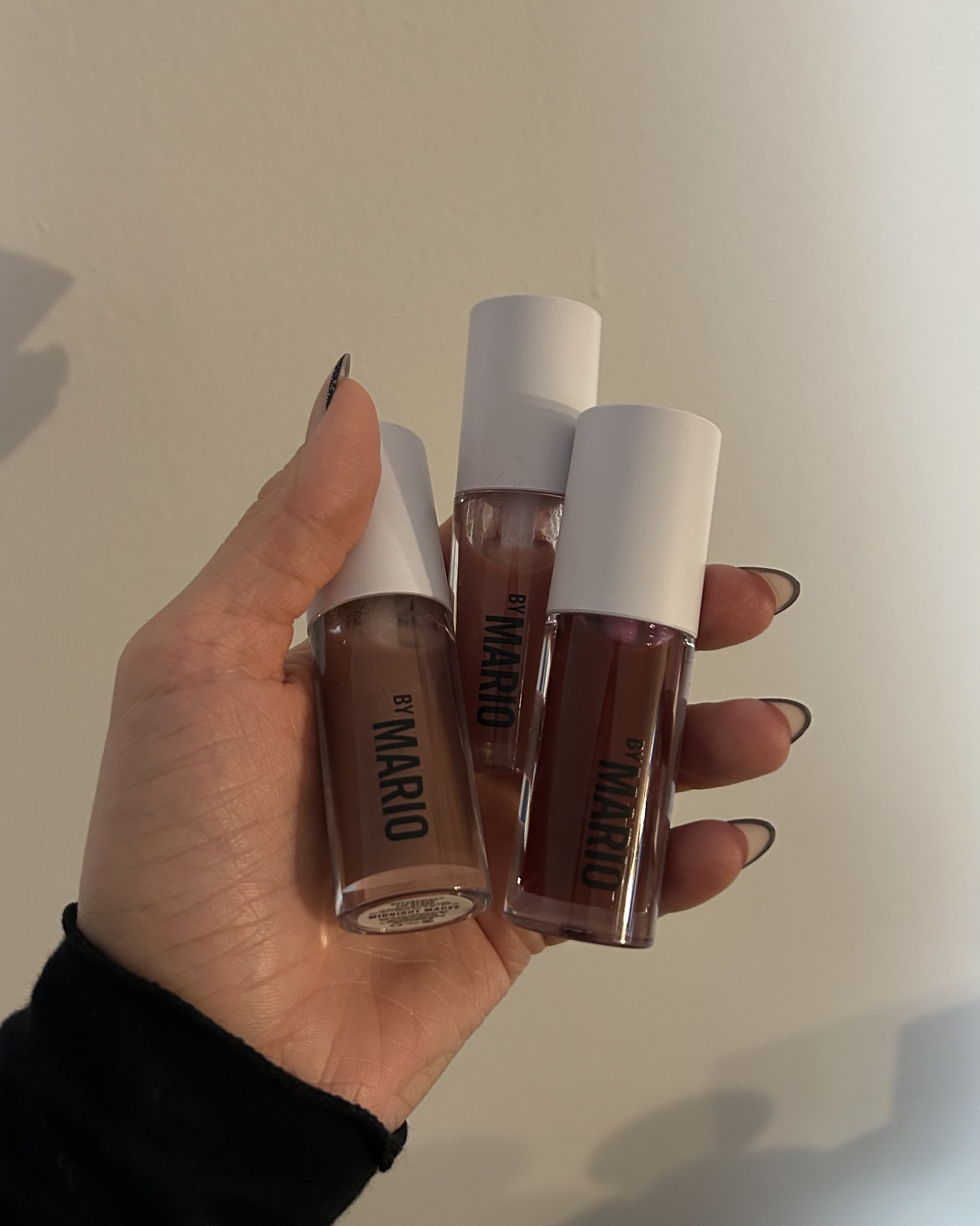 Alyssa Brascia holding several Makeup by Mario Supershine Lip Glosses.