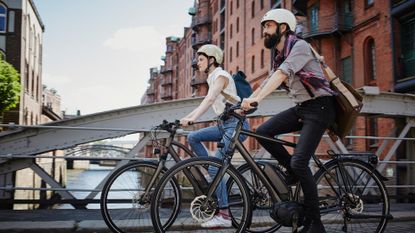 Image shows two people riding electric bikes.