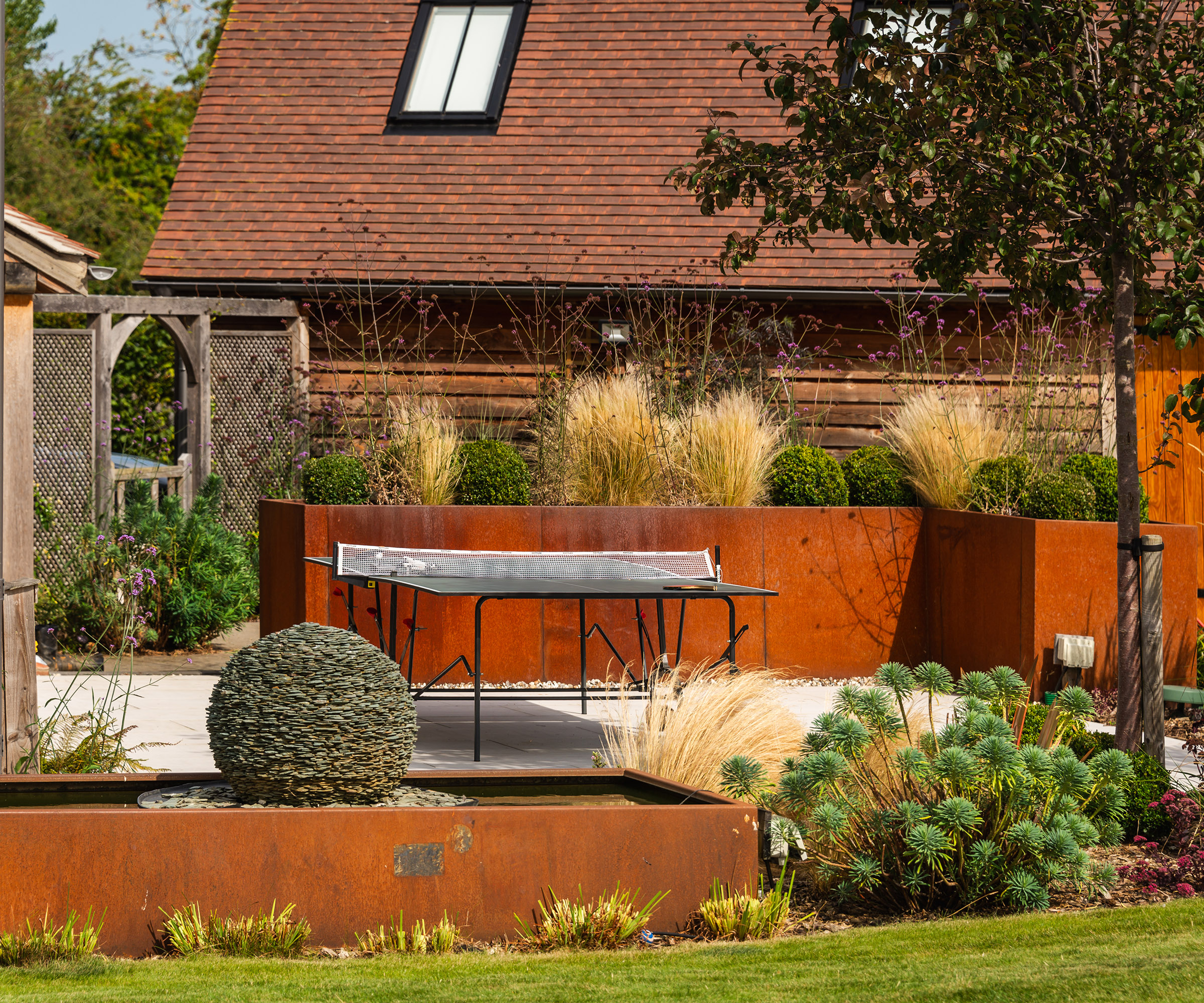 Corten steel raised planters in a landscaped garden