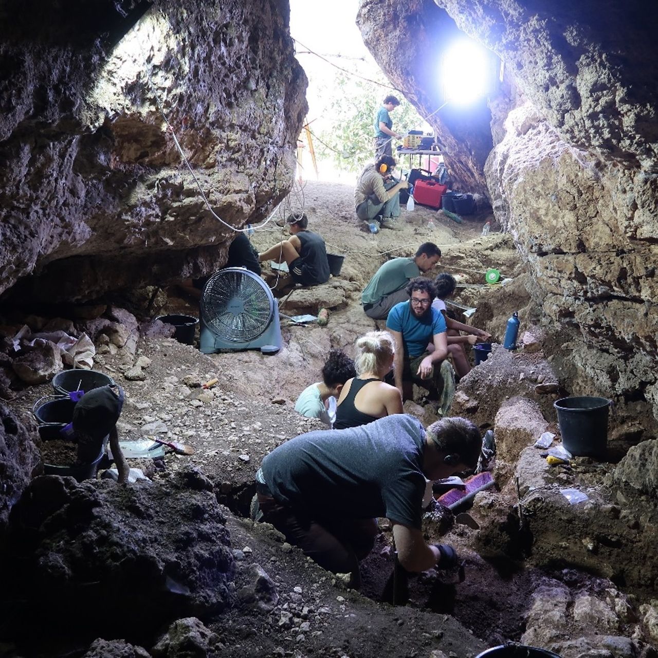 A group of archaeologists excavate in a cave