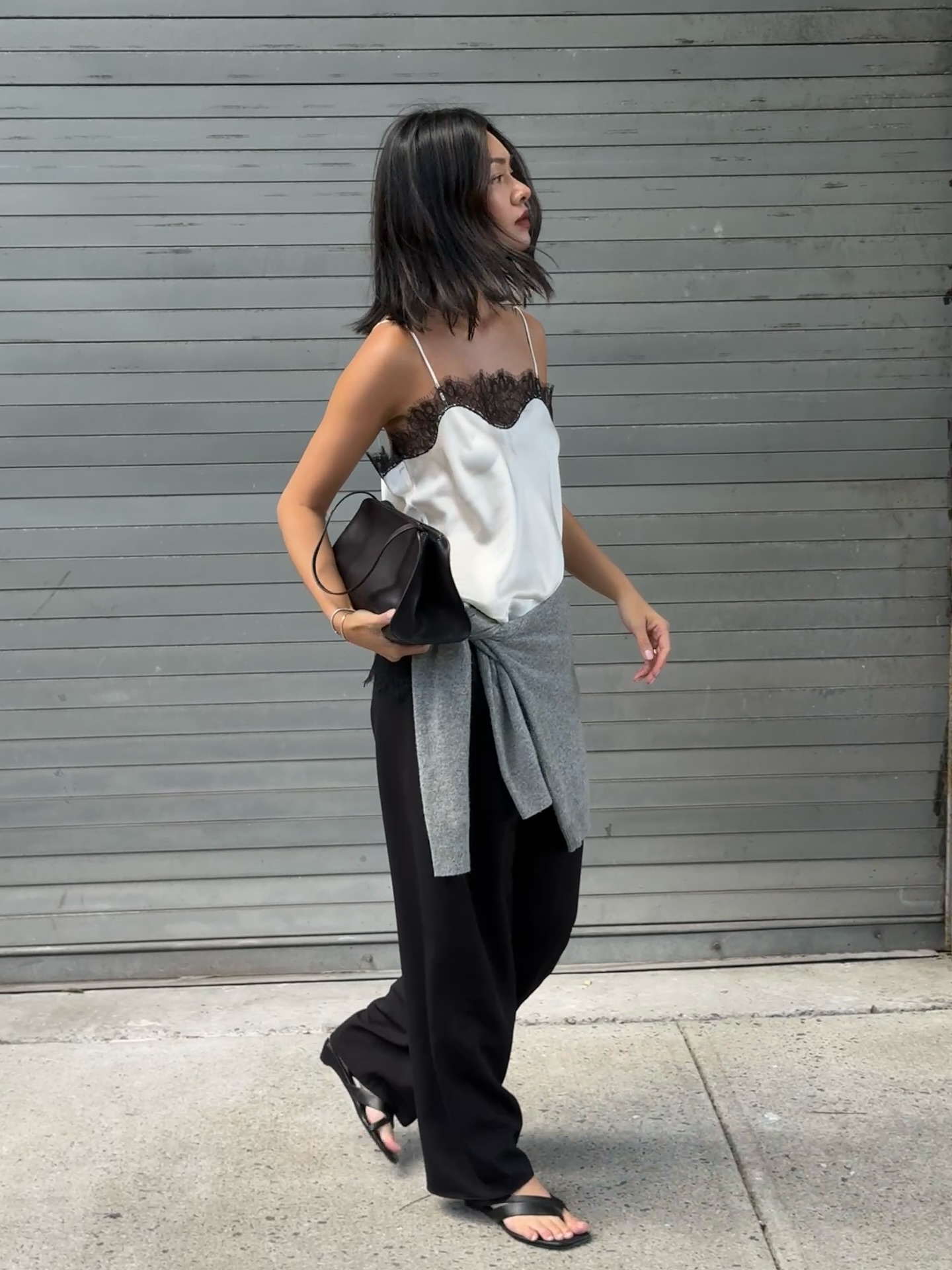 mimixn wears a camisole top, black wide leg trousers and leather flip flops