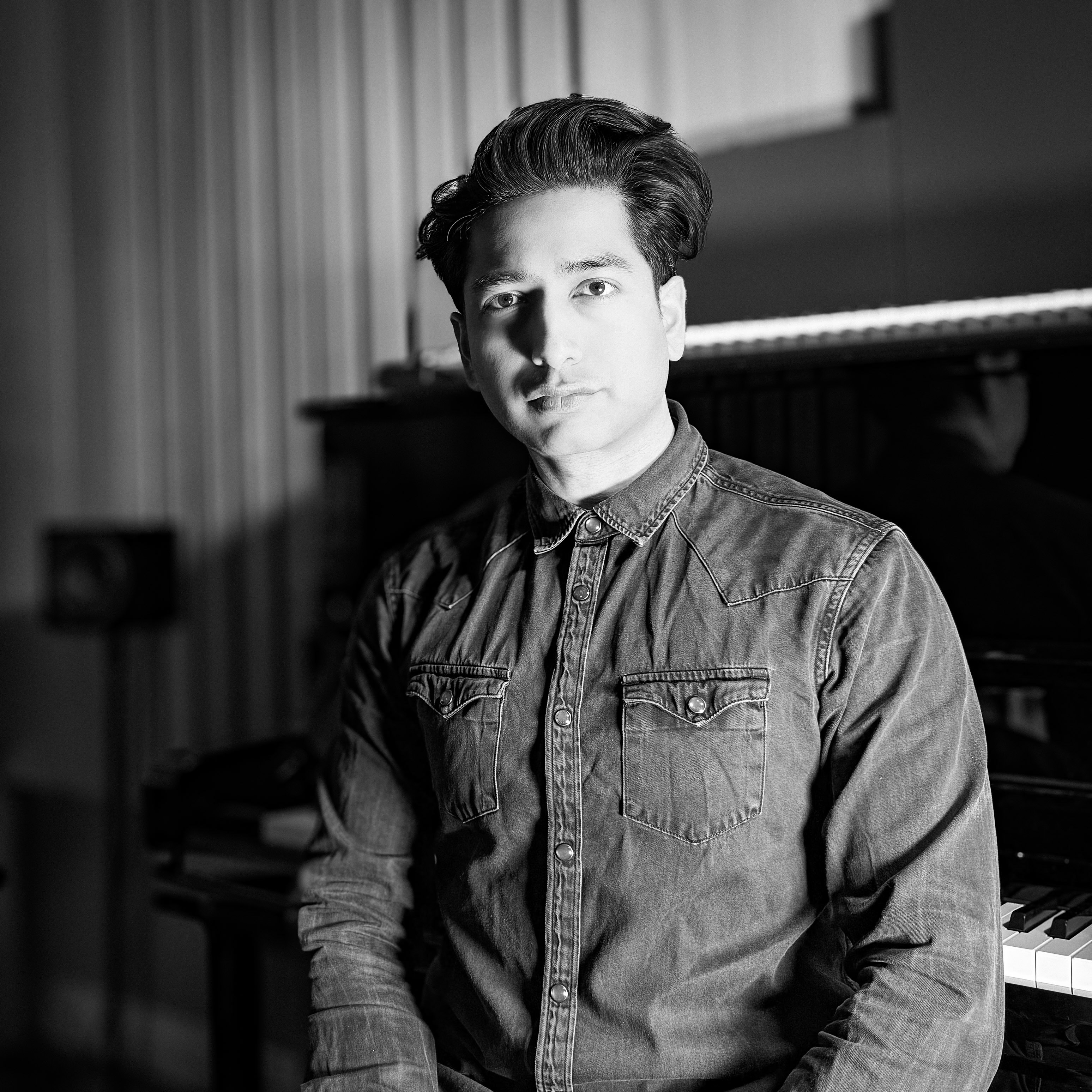 Animesh Raval press shot in front of piano
