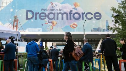 Entrance to the 2025 Dreamforce conference at the Moscone Center, San Francisco, with attendees queuing up and pedestrians walking past.