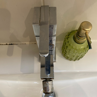 My bathroom tap before trying the viral candlewax polish hack.