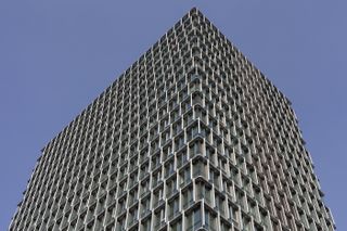 Piraeus Tower, a high rise in Athens with its renovation works completed by PILA, seen in hero glory, gleaming facade and slanted fin shading