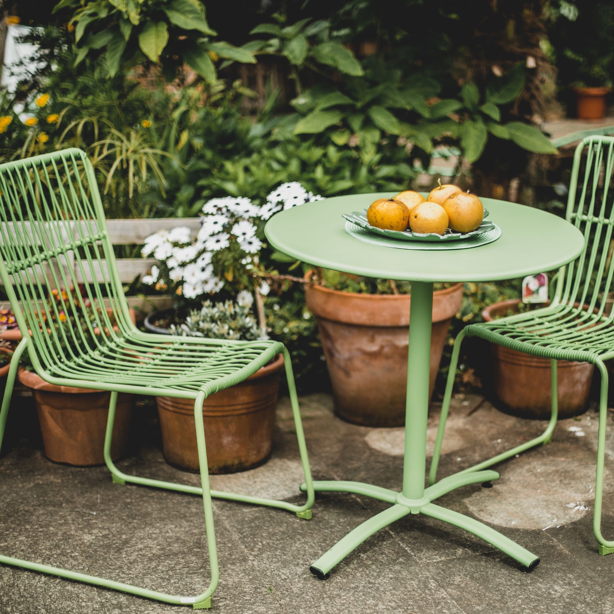 small green table and chairs on patio with potatoes on table
