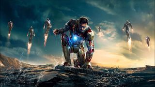 Une image promotionnelle d'Iron Man 3 montrant Tony Stark agenouillé avec ses combinaisons volant autour de lui.