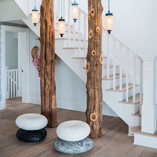spaces under stairs with tree trunks lantern and stone effect cushions