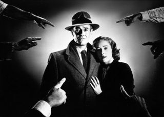 a man and a woman in a spotlight being pointed at by various fingers in the movie the wrong man