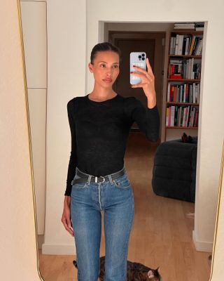 Woman wearing skinny jeans with a black T-shirt.