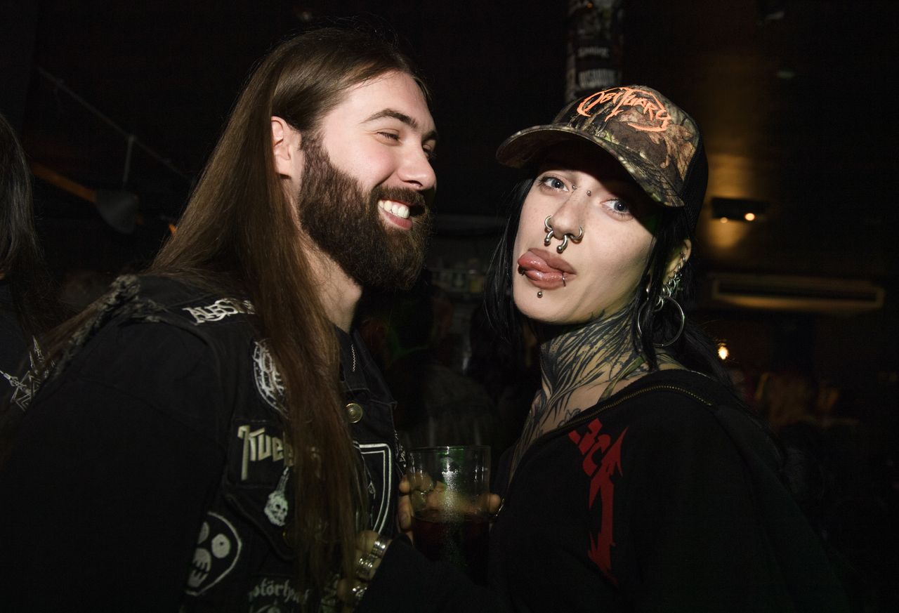 People drinking, smiling and throwing horns at the Metal Hammer 400 party