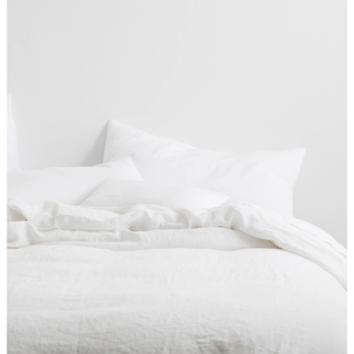 white linen duvet and pillows on a bed