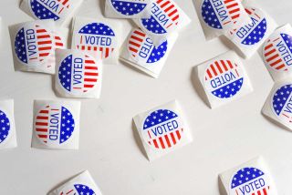 "I voted" stickers on white table