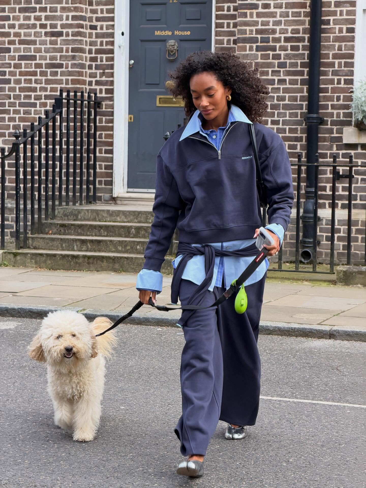 Influencer Chey Maya wearing a half-zip sweatshirt, sweatpants and oversized shirt.