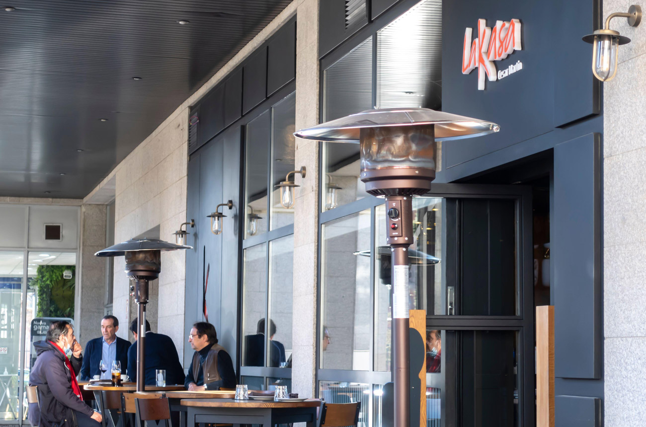 Restaurant terrace with a group of men sitting at high tables