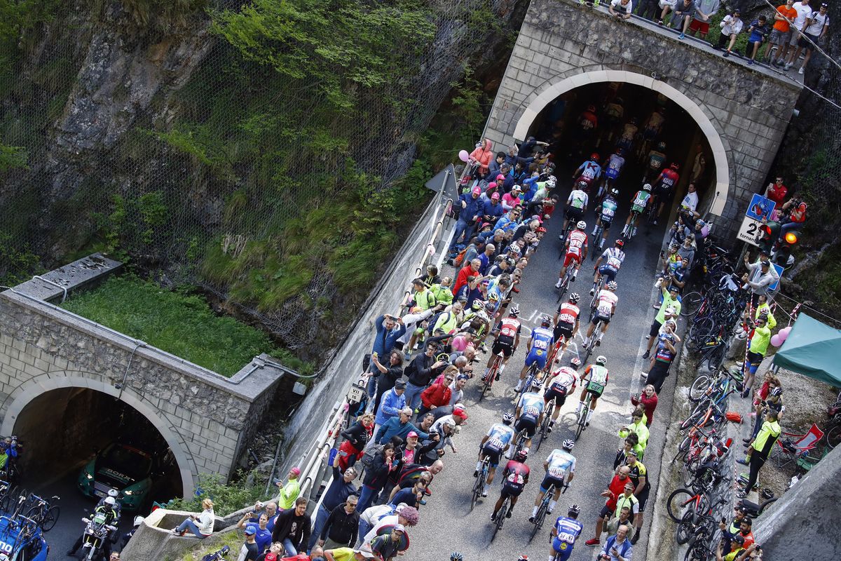 The peloton pass through a tunnel on the Passo di San Boldo