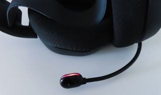 Lähikuvassa SteelSeries Arctis 7+ -pelikuulokkeiden mikrofoni, jonka punainen väri kertoo mykistyksestä.