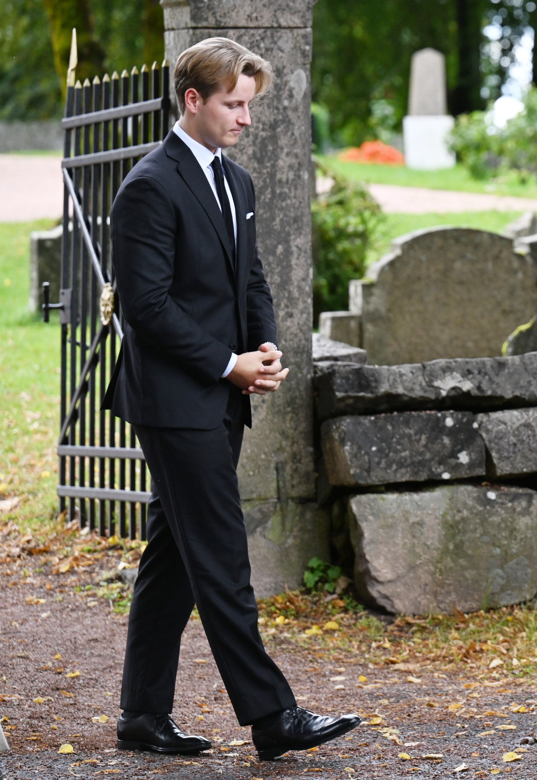 Prince Sverre Magnus of Norway walking through a graveyard