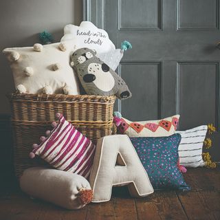 A large wicker storage basket filled with cushions