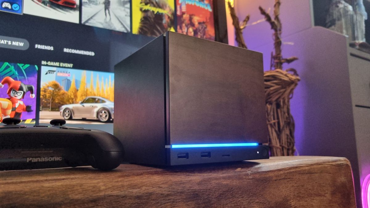 A Steam Machine with a wood faceplate attached, in front of a TV