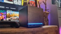 A Steam Machine with a wood faceplate attached, in front of a TV
