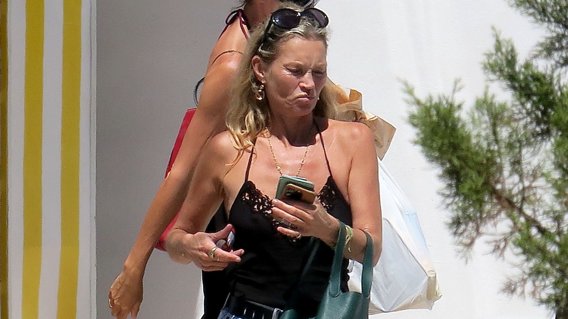 An image of Kate Moss wearing a denim mini skirt with gladiator sandals. 