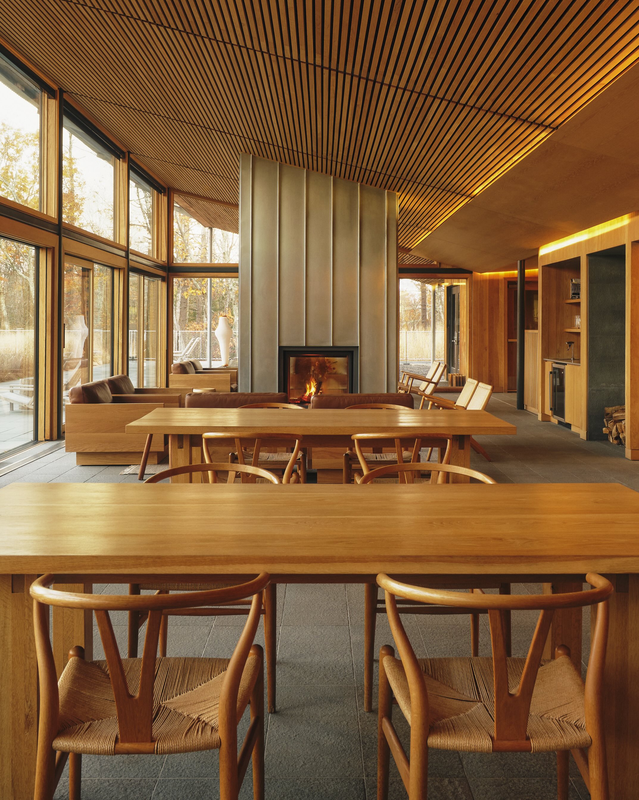 A photo of wishbone chairs around wooden tables at the Piaule hotel in the Catskills.
