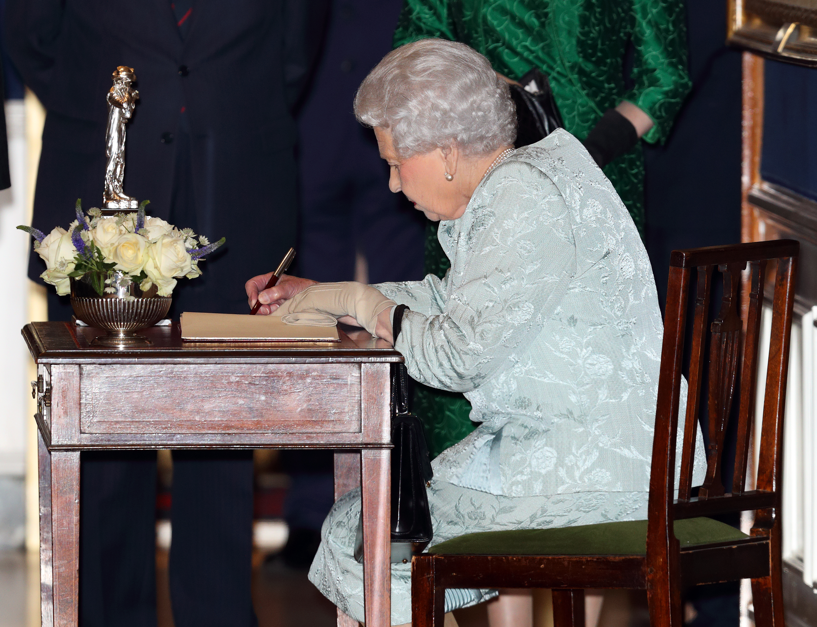 LONDON, UNITED KINGDOM - OCTOBER 12: (EMBARGOED FOR PUBLICATION IN UK NEWSPAPERS UNTIL 48 HOURS AFTER CREATE DATE AND TIME) Queen Elizabeth II signs a visitors book as she attends a reception to mark the Centenary of the Women&amp;amp;apos;s Royal Navy Service and the Women&amp;amp;apos;s Auxiliary Army Corp at The Army &amp;amp; Navy Club on October 12, 2017 in London, England. (Photo by Max Mumby/Indigo/Getty Images)