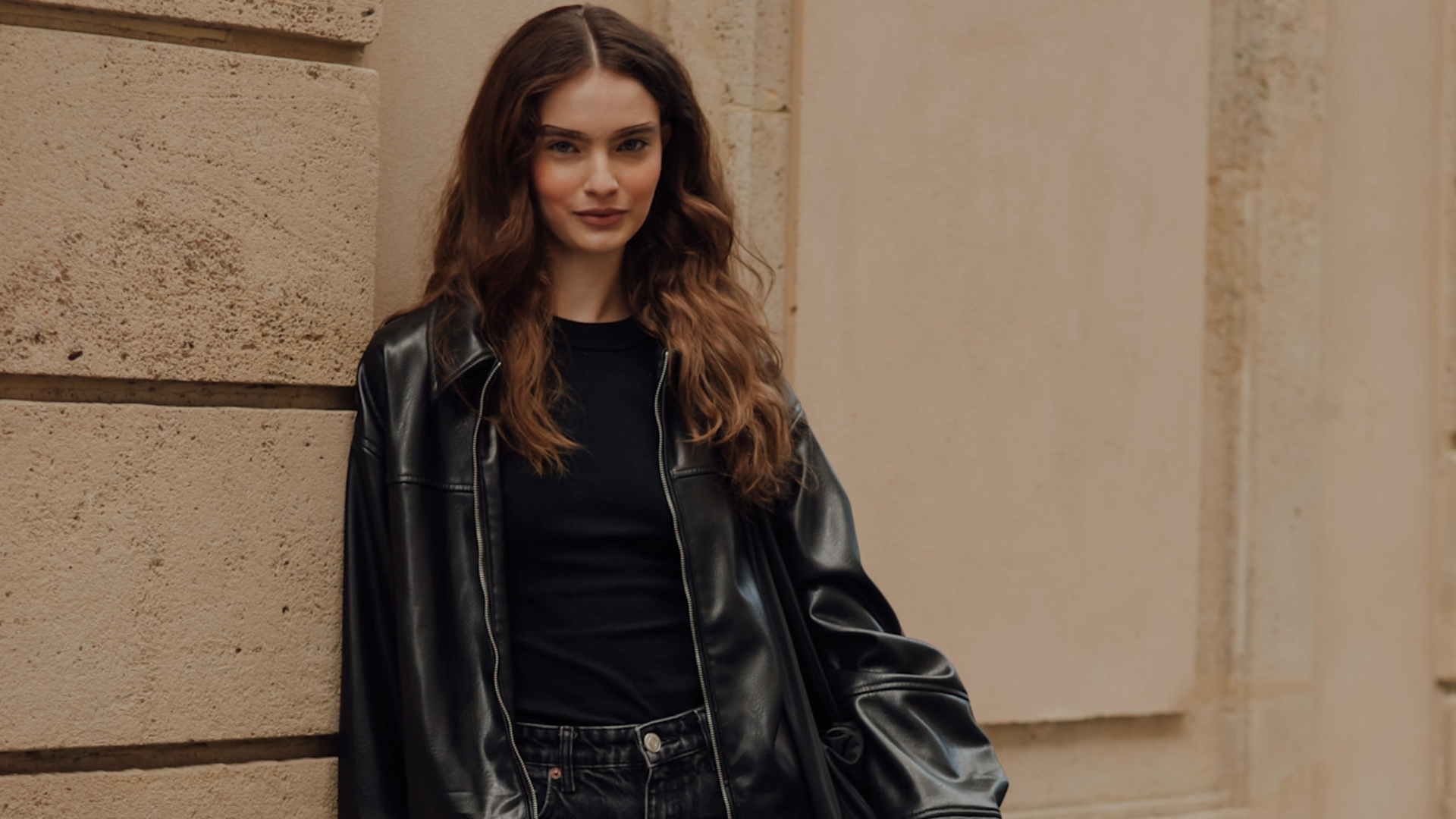 woman wearing a black t-shirt and a black leather jacket. 