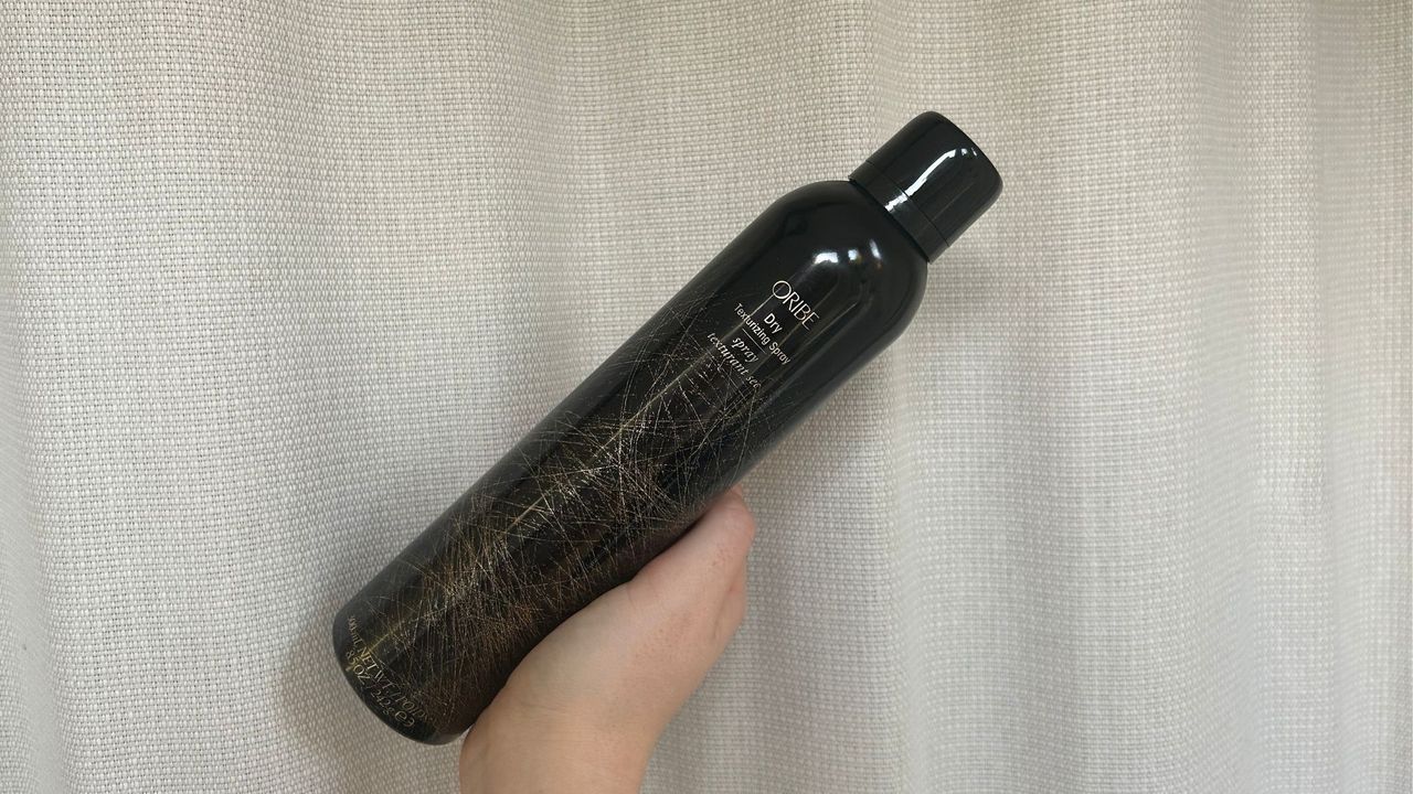 Tori holding a bottle of the Oribe Texturizing Spray for her Oribe Texturizing Spray review