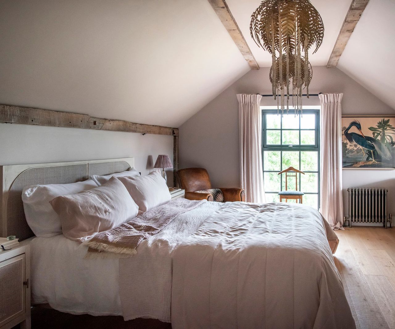 An upstairs bedroom with wooden beams and wooden flooring
