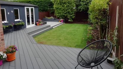 Grey composite decking in garden with container plant pots