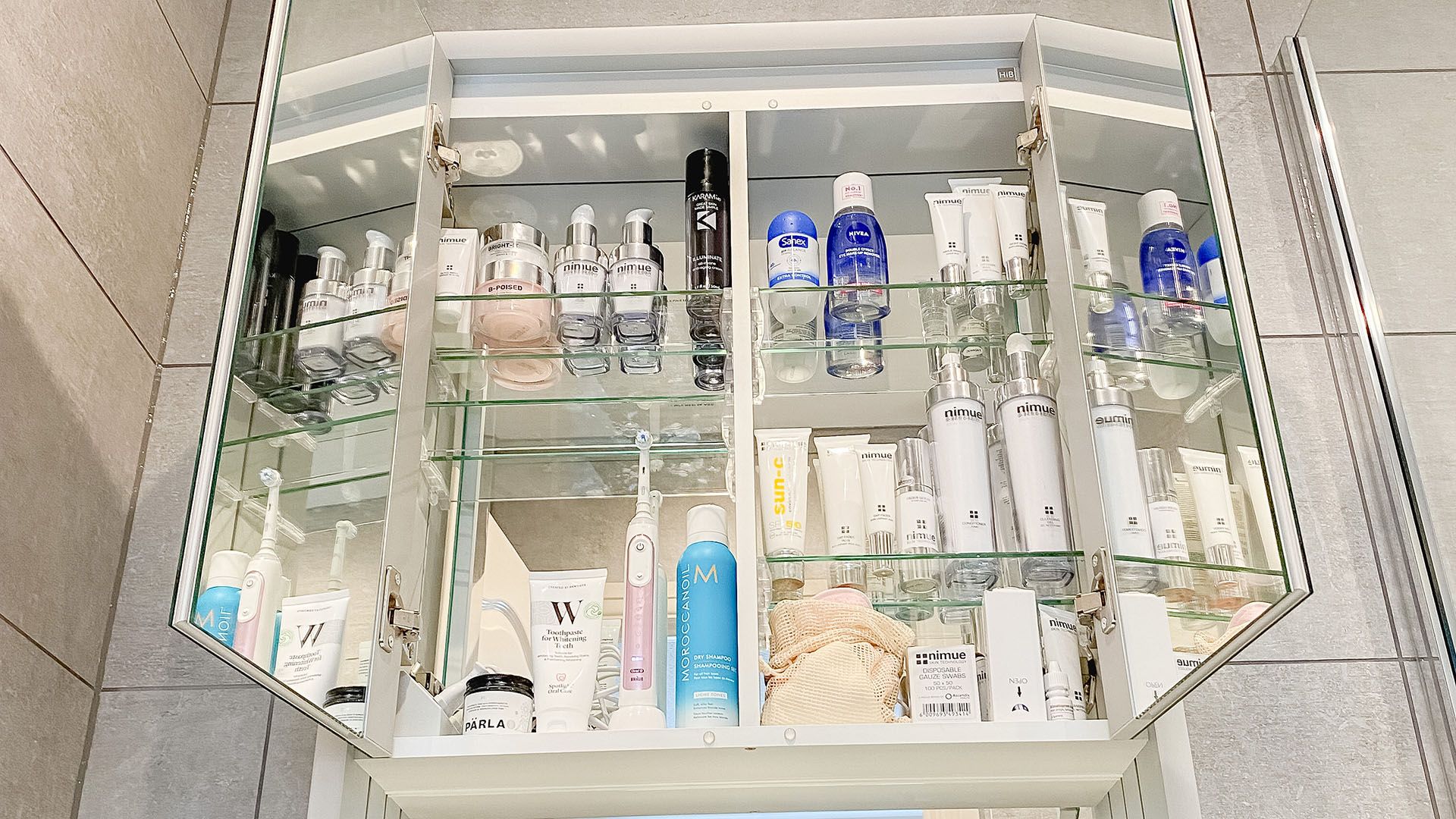 clean and tidy bathroom showing inside of the cupboard, all organised