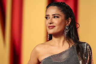 Salma Hayek wears a sparkling silver dress and stares off to the side at the 2024 Oscar awards.