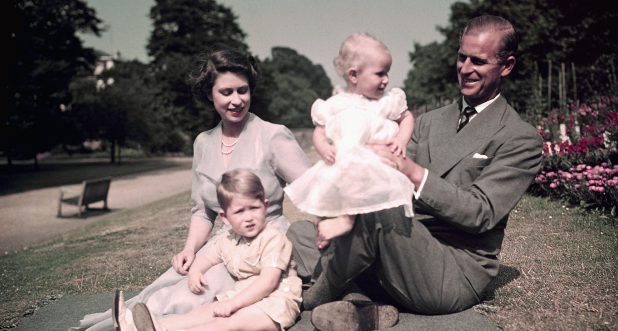 Queen Elizabeth and Prince Philip sitting on a blanket with Princess Anne and Prince Charles at Balmoral