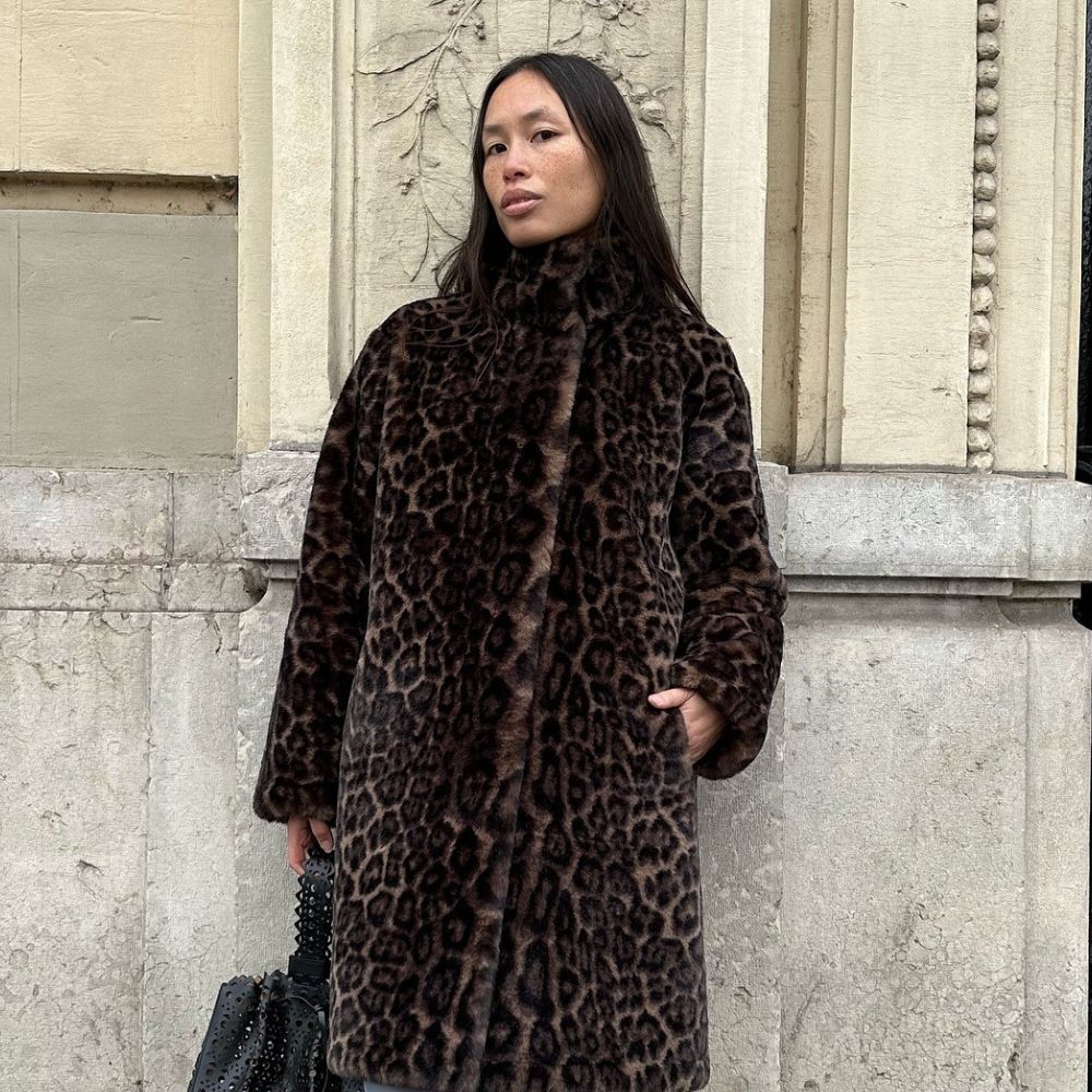 Influencer @vikilefevre wears a leopard print coat with blue tights and black slingback heels.