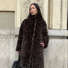 Influencer @vikilefevre wears a leopard print coat with blue tights and black slingback heels.