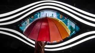 Umbrella Eye - A person walks past a giant eye on a shopping facade, with a colorful umbrella positioned perfectly at the center, creating the illusion of an 'umbrella eye.' 