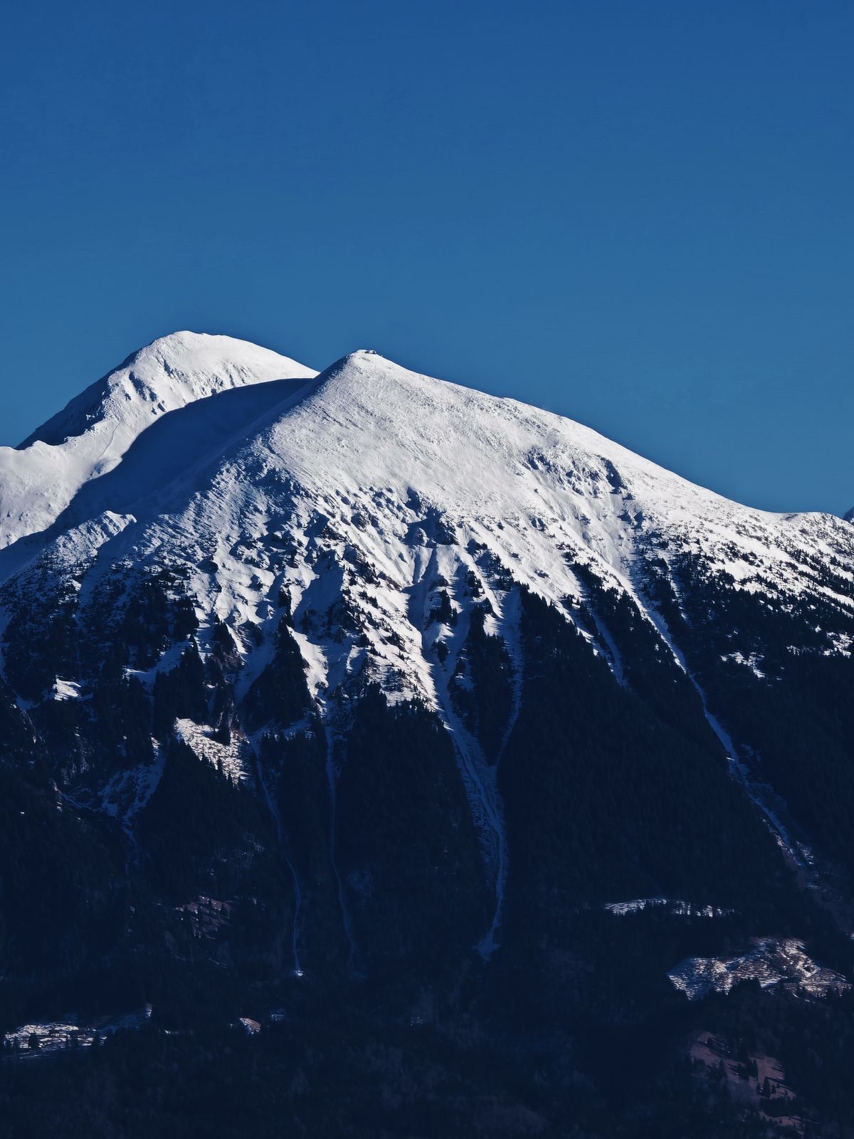 Snow capped mountain in front of a blue sky