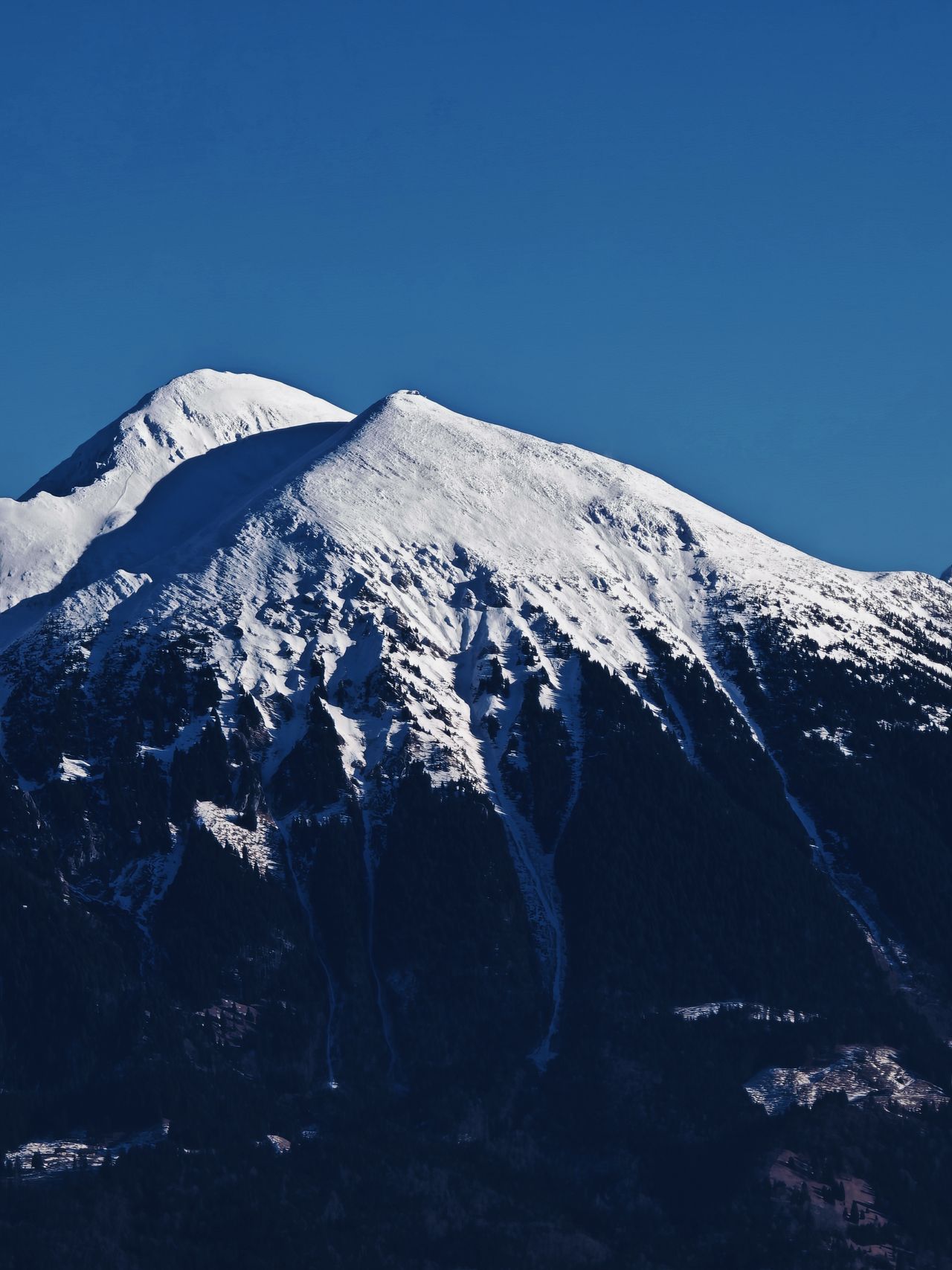 Snow capped mountain in front of a blue sky