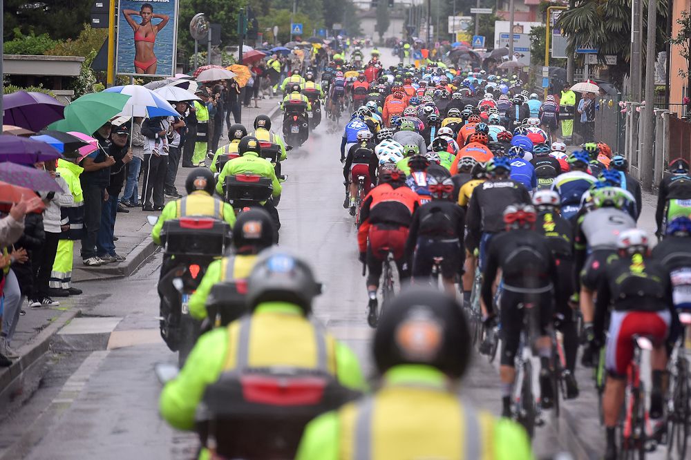 The peloton makes it's way down another wet road.