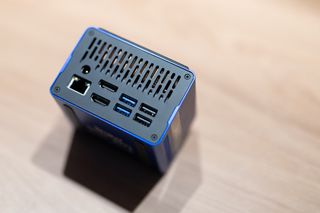 A blue and black Xulu XR1 Max mini PC on a wooden desk