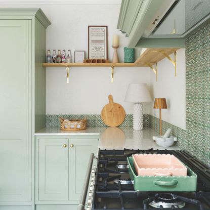 White painted kitchen with green tiles on the wall and green kitchen cupboards