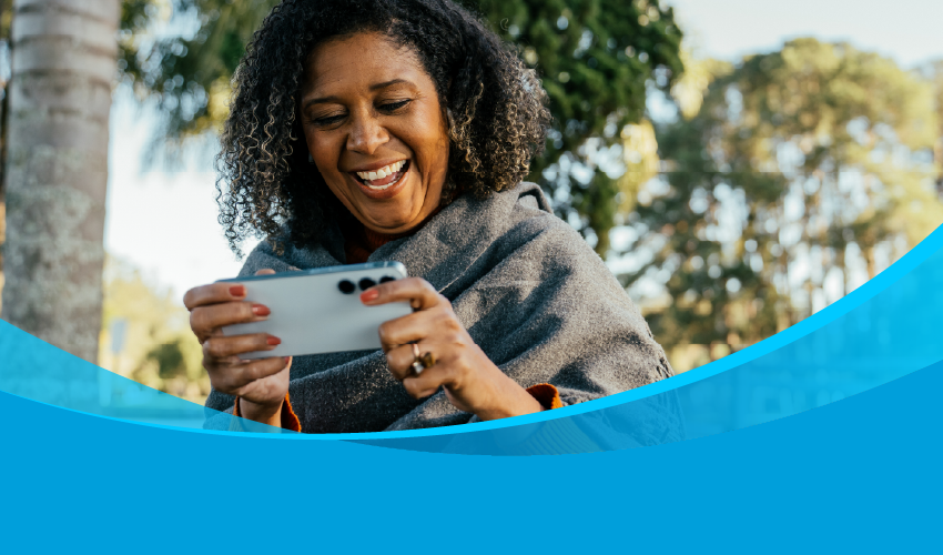 Woman smiling while using an phone on an AT&amp;T network