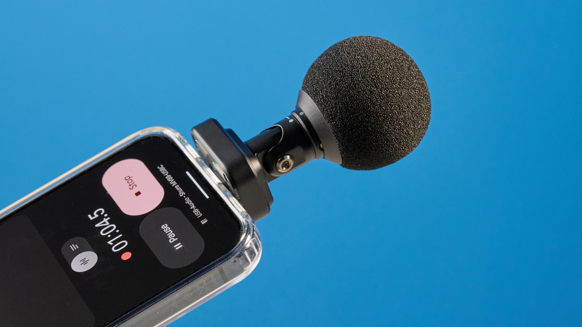 the shure mv88 usb-c microphone photographed against a blue tom's guide background and shown connected to a google pixel 10 pro