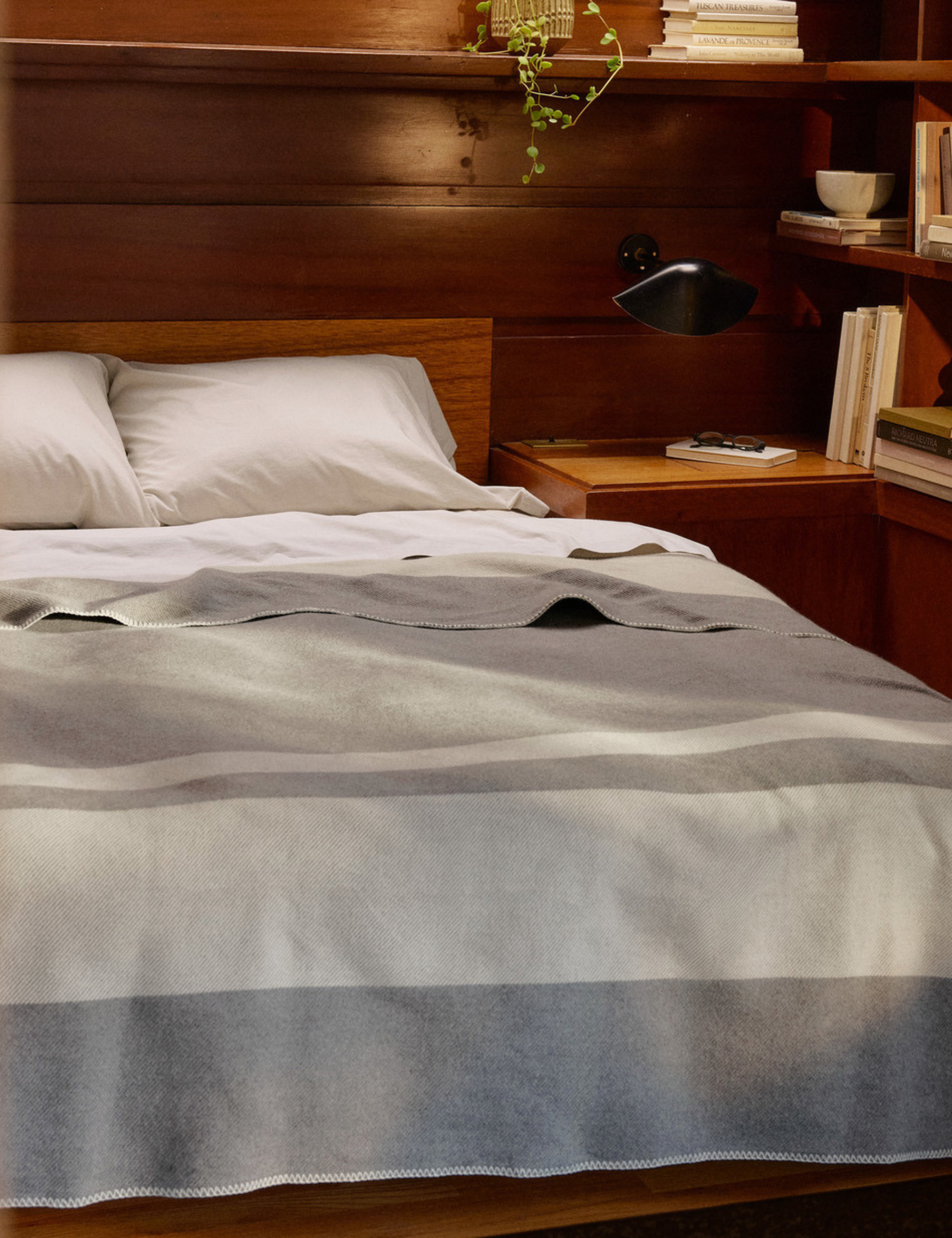 Parachute for Target cotton bed sheets and bed blanket styled inside of a wood-paneled mid-century-style bedroom.