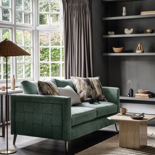 should small rooms be painted in light or dark colours, grey living room with emerald green sofa, grey painted open shelving, ornaments, rug, dark wood floor